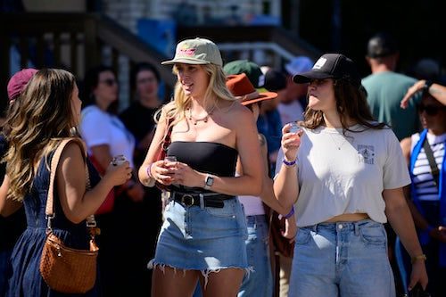 Three women standing together at the Beer Fest holding the beer glasses.
